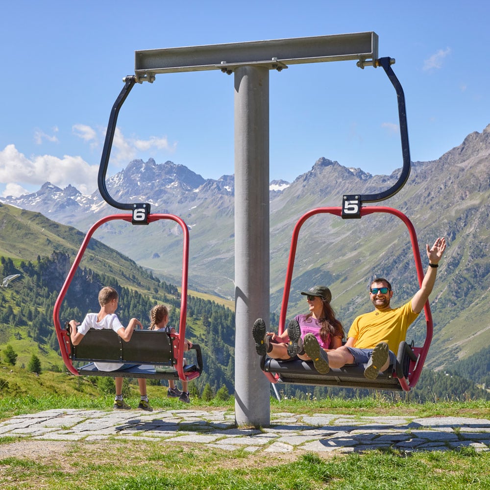 Zwei Familien genießen einen Sessellift während ihres Sommerurlaubs in Ischgl.