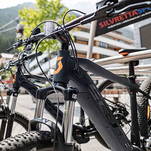 Nahaufnahme eines schwarzen Mountainbikes, das während des Sommerurlaubs in Ischgl im Freien abgestellt ist.