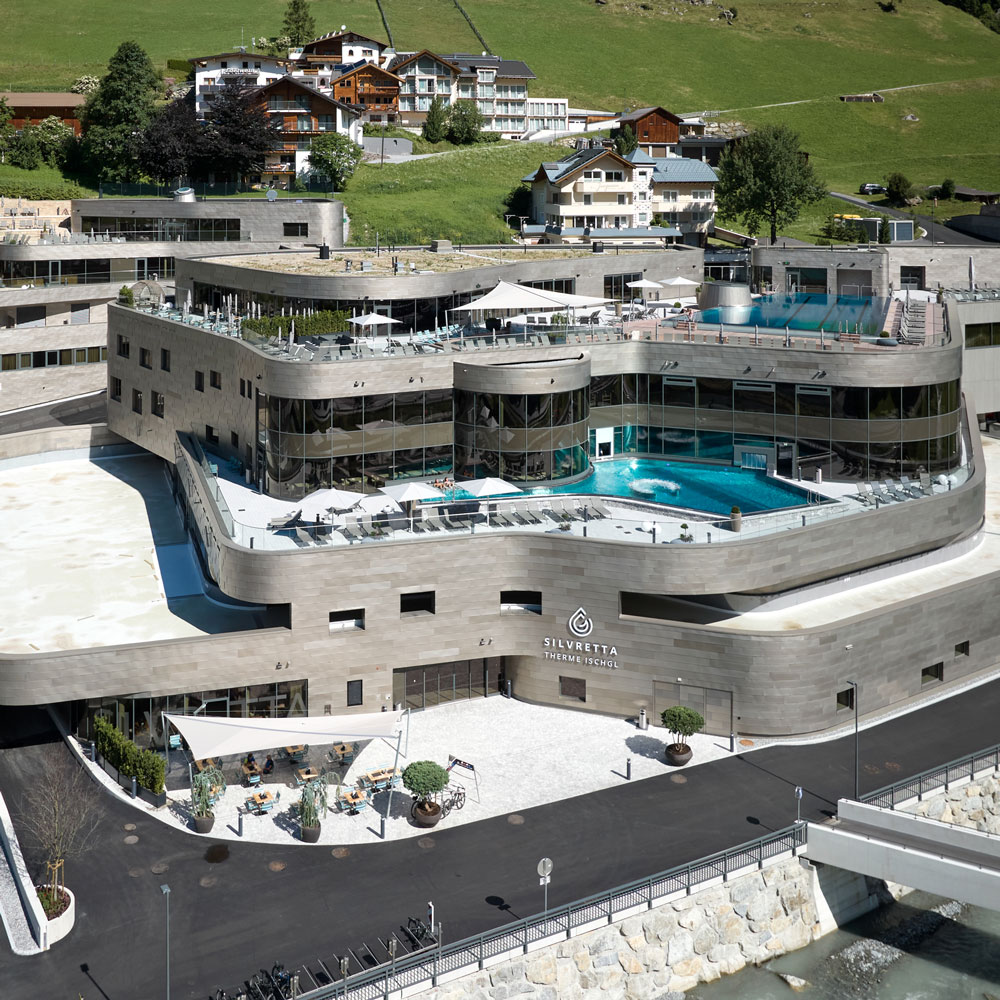 Modernes Hotel mit Dachpool, Terrassen und Sommerurlaub in Ischgl mit Blick auf das Bergdorf.